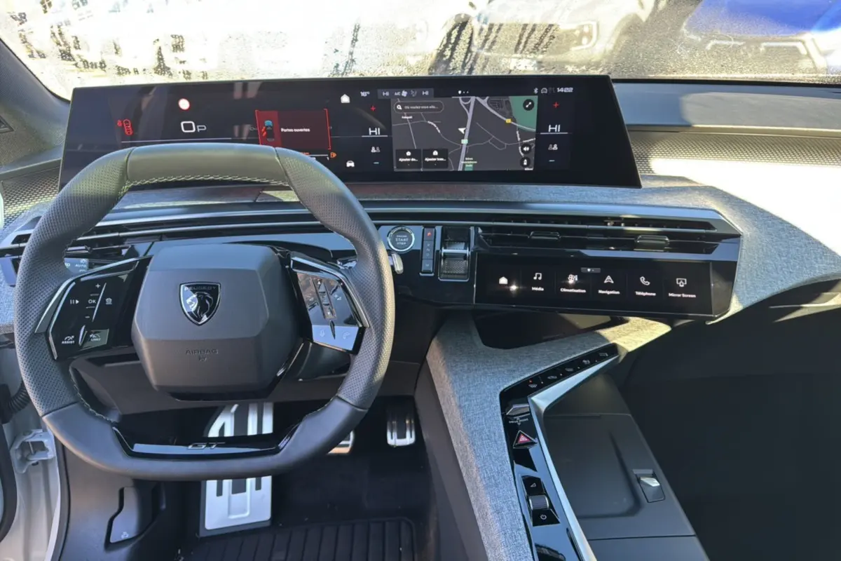 Vue intérieure du tableau de bord du Peugeot 3008 Hybrid 2024 avec volant compact et écrans numériques larges.