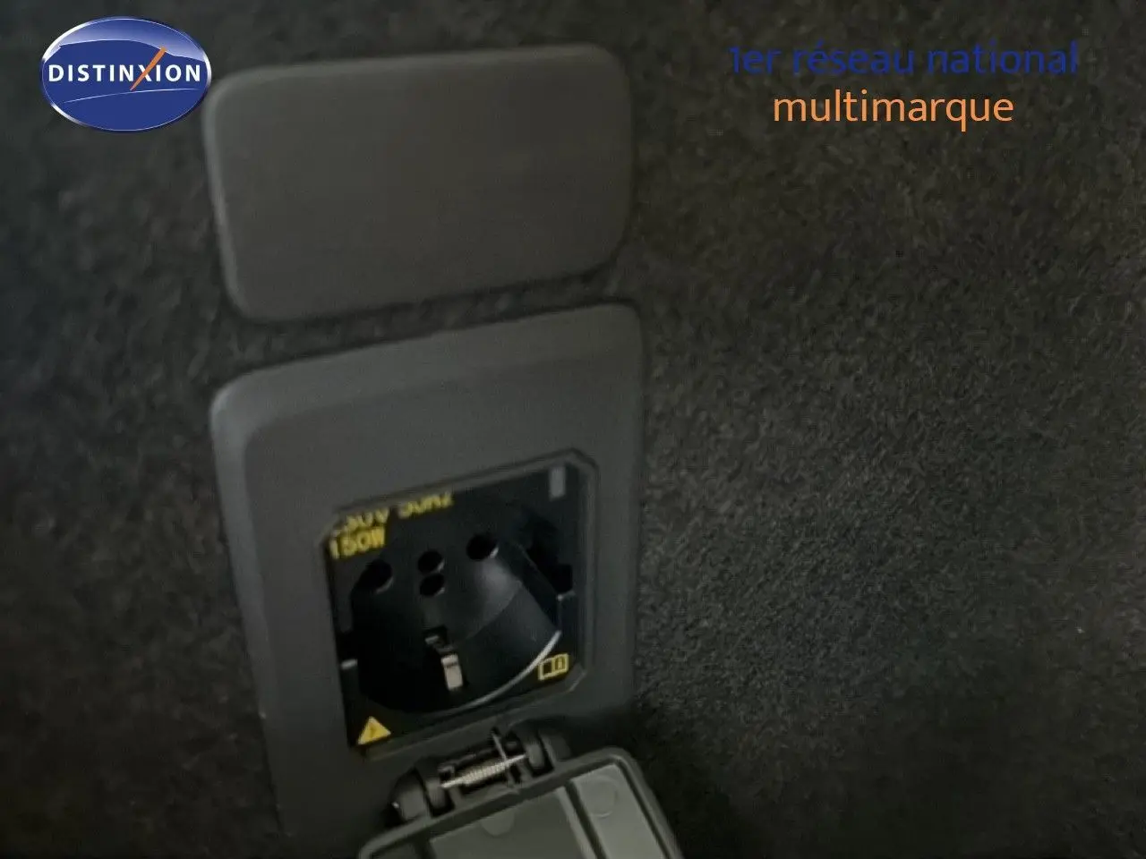 Prise électrique 230V intégrée dans le coffre du CUPRA LEON ST gris magnétique 2025, vue rapprochée intérieure.