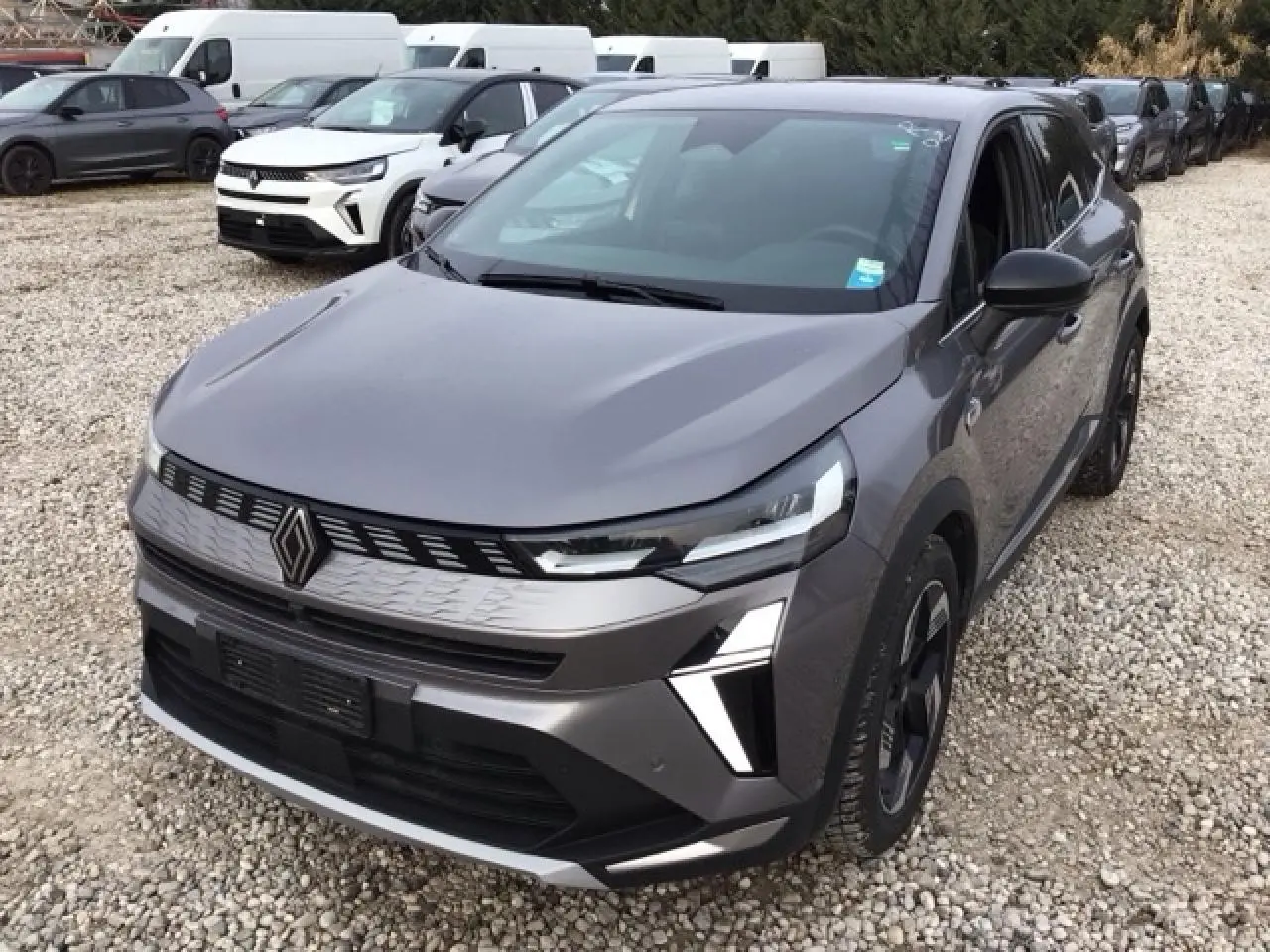 Vue 3/4 avant droit d'une Renault SYMBIOZ gris Cassiopée avec calandre 3D et feux LED distinctifs.