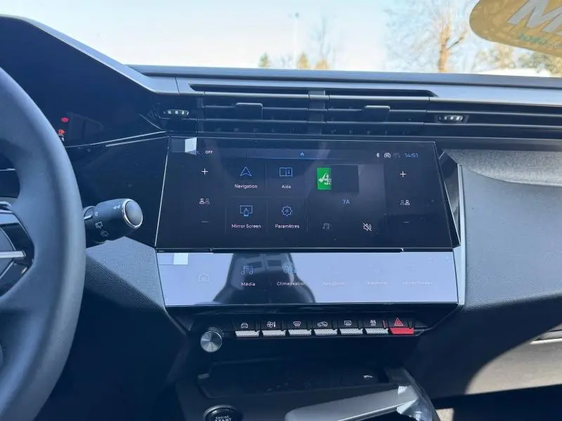 Vue rapprochée du tableau de bord de la Peugeot 308 2025 avec écran tactile central et commandes tactiles sous écran.