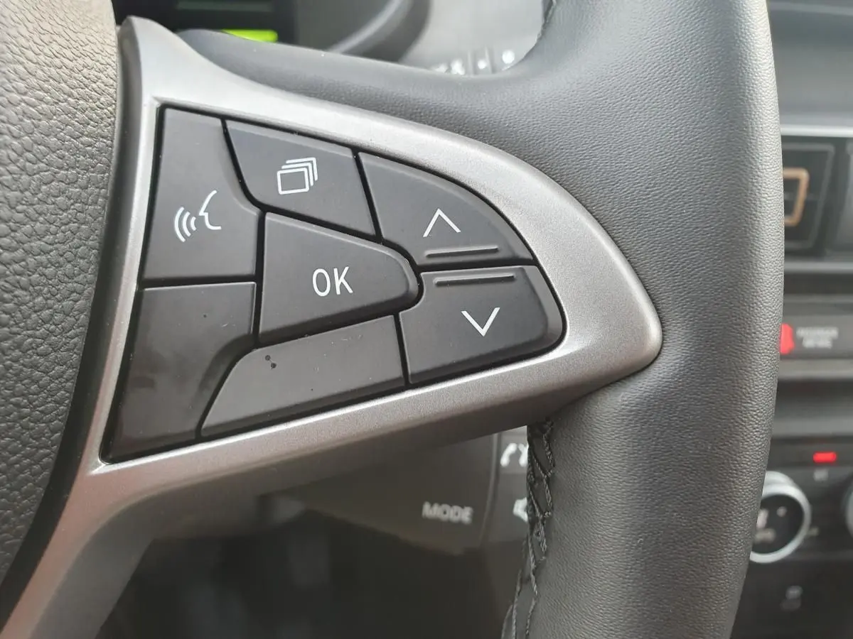 Gros plan sur les commandes multifonctions à gauche du volant du Dacia Jogger, intérieur noir.