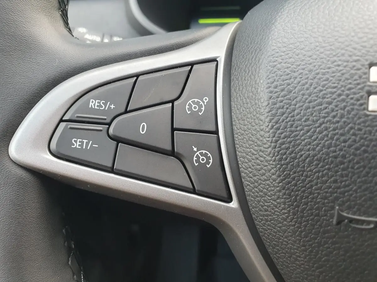 Gros plan sur les commandes de régulateur de vitesse à gauche du volant du Dacia Jogger 2026, intérieur noir.