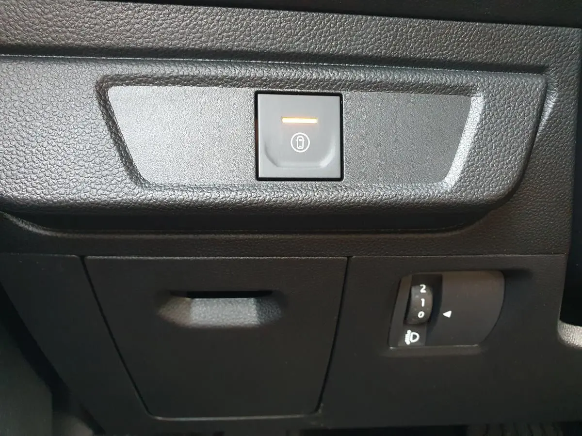 Détail intérieur du tableau de bord du Dacia Jogger 2026, bouton de verrouillage centralisé et réglage des phares.