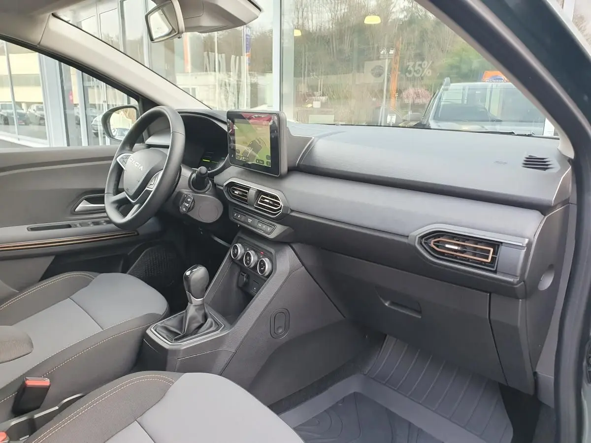 Vue intérieure côté passager du tableau de bord et console centrale du Dacia Jogger 2026, avec écran tactile et finitions noires.