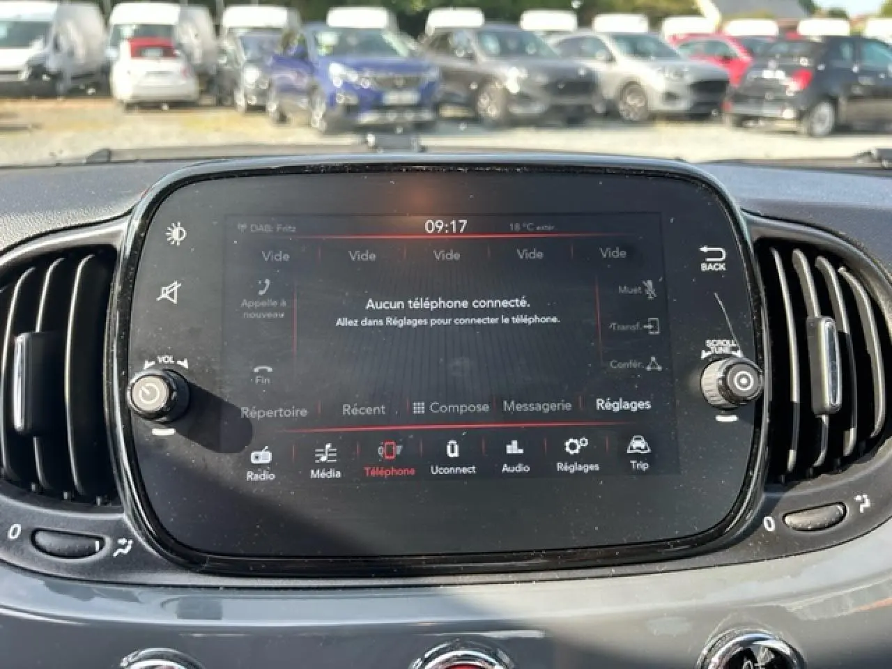 Écran tactile central de la Fiat 500C gris/rouge, affichant le menu téléphone avec commandes autour.