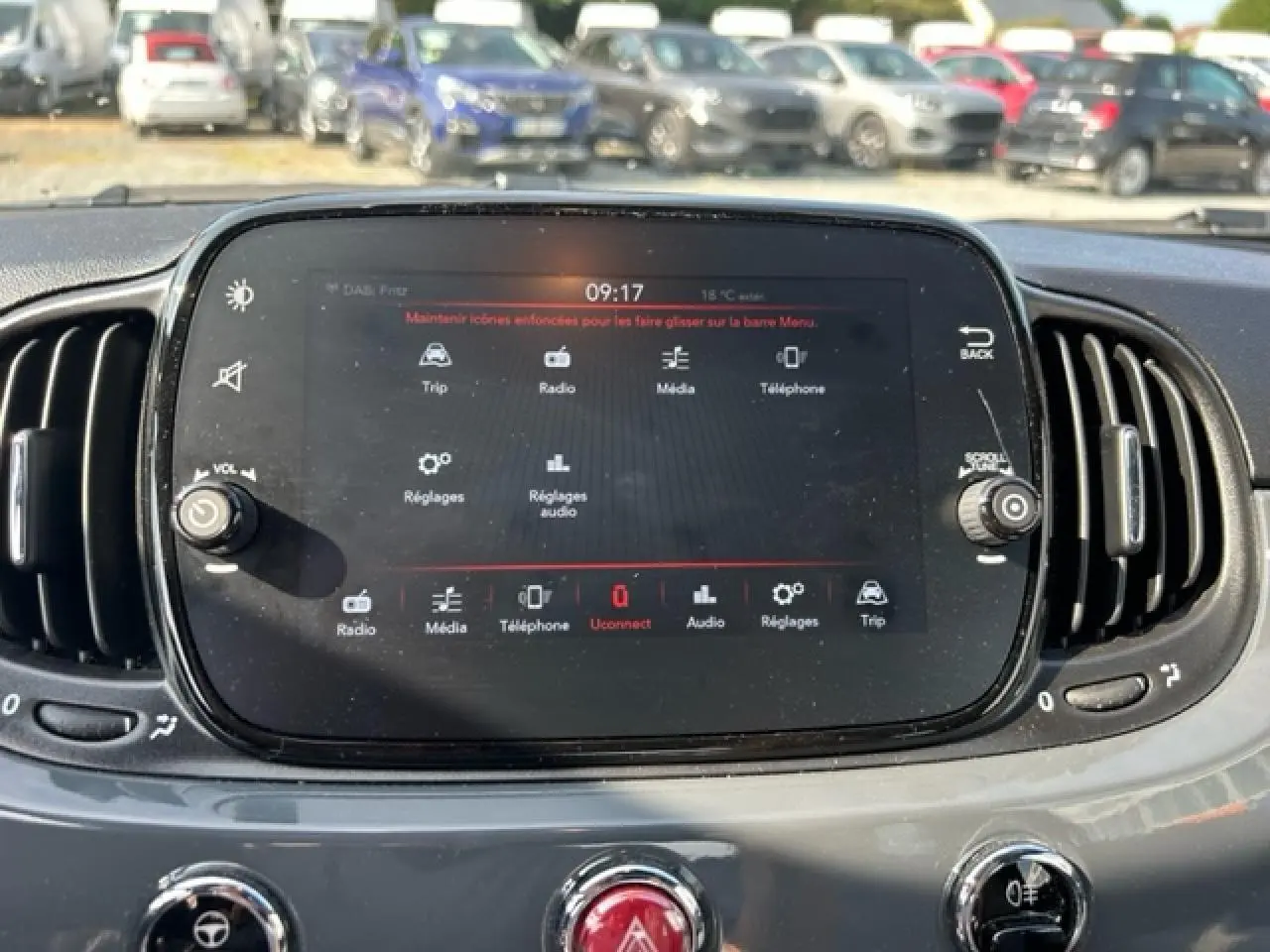 Écran tactile central du tableau de bord de la Fiat 500C 2021, avec commandes multimédia et aérateurs latéraux noirs.