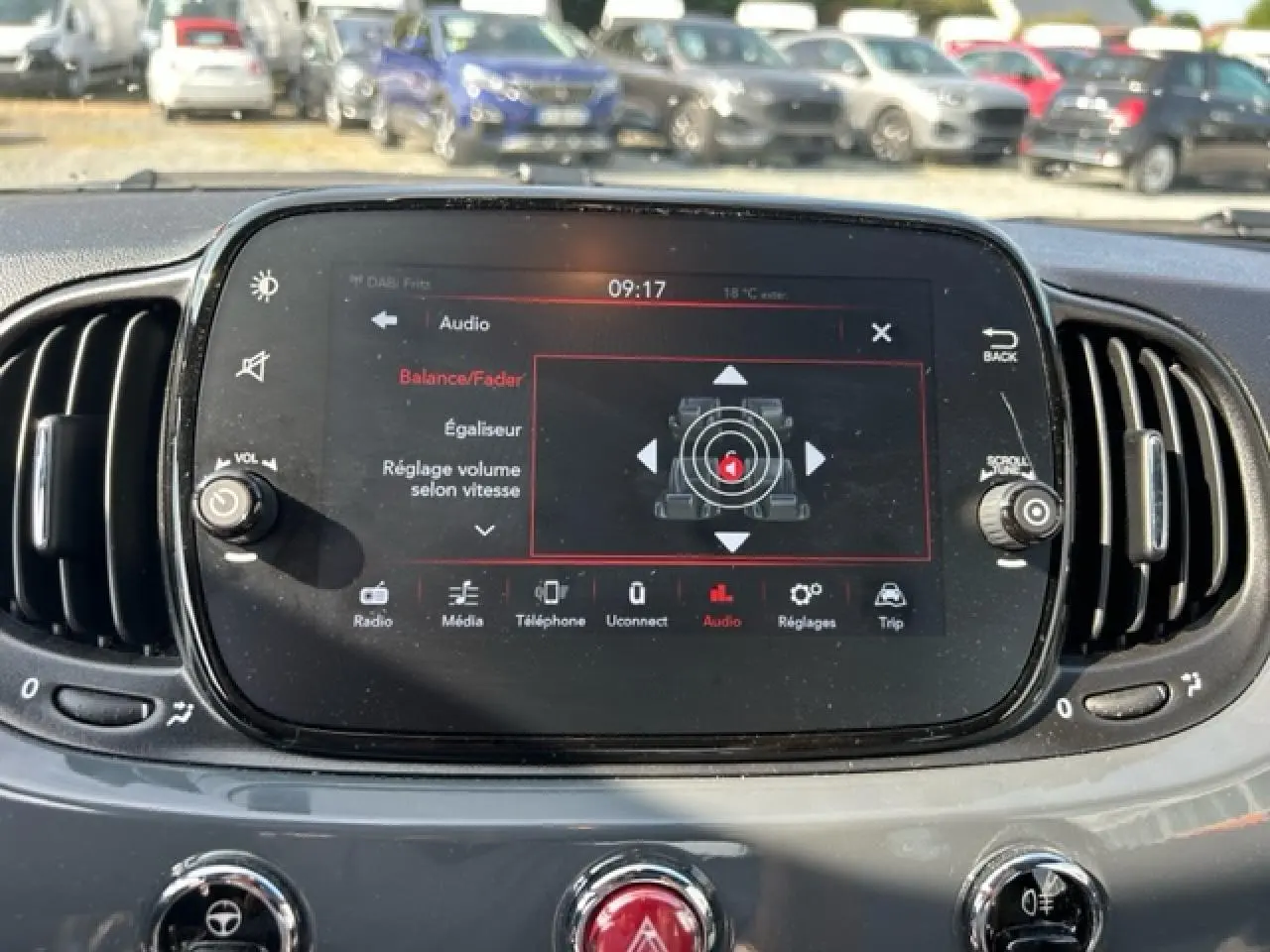 Écran tactile central du tableau de bord de la Fiat 500C 2021, affichant les réglages audio avec commandes autour.