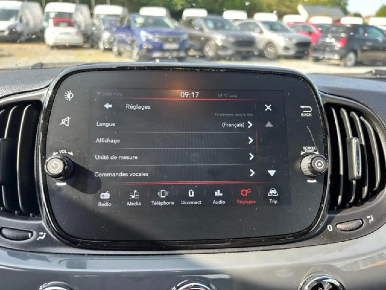Vue rapprochée de l'écran tactile central du tableau de bord gris d'une Fiat 500C cabriolet, affichant le menu Réglages.