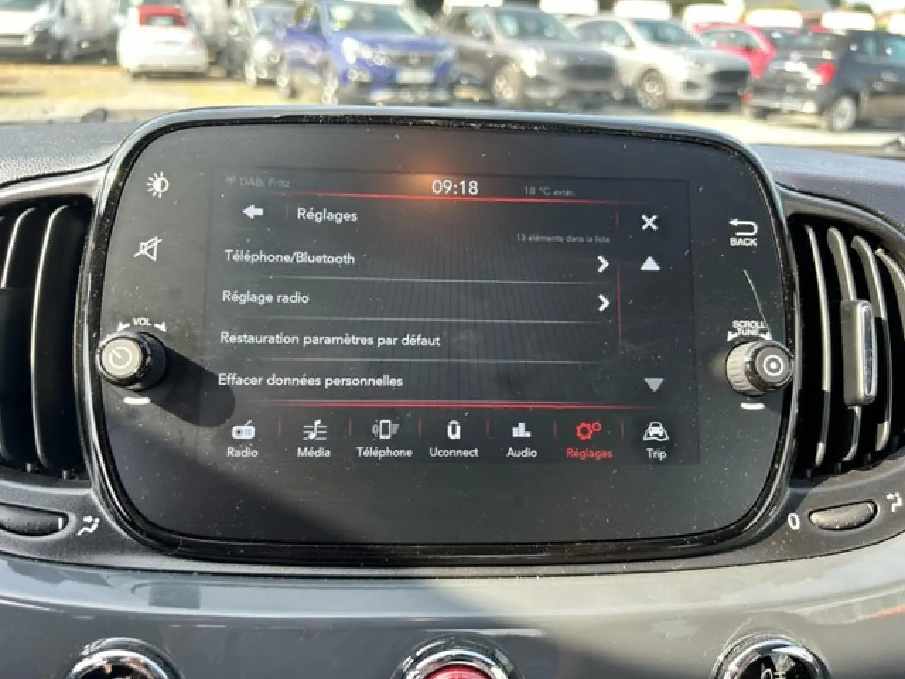 Écran tactile central de la Fiat 500C 2021 affichant le menu Réglages, avec commandes autour et tableau de bord gris.