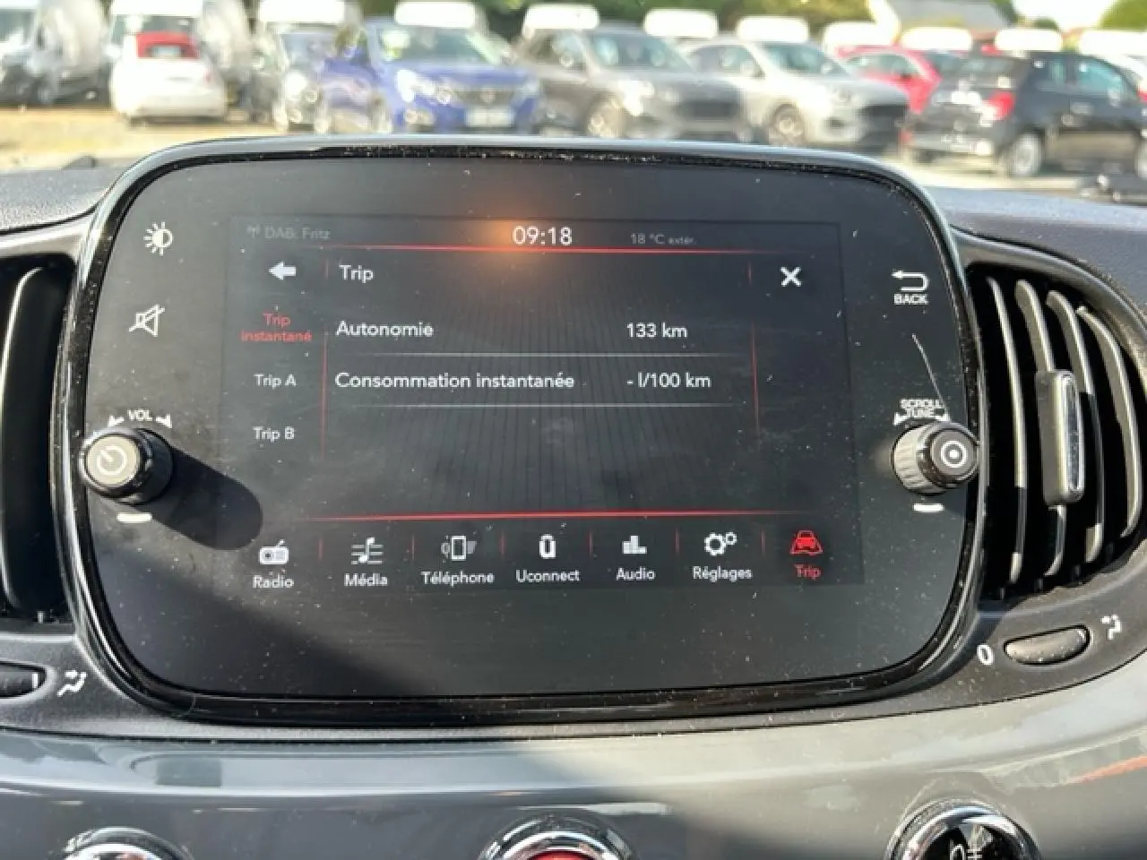 Écran tactile central de la FIAT 500C gris/rouge affichant les informations de trajet et la température extérieure.