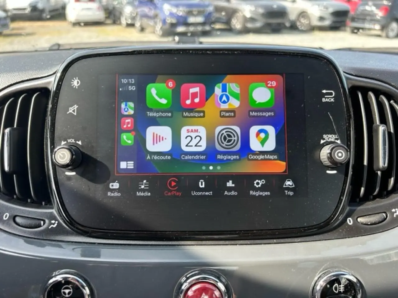 Écran tactile central avec interface Apple CarPlay dans le tableau de bord d'une Fiat 500C gris/rouge cabriolet.