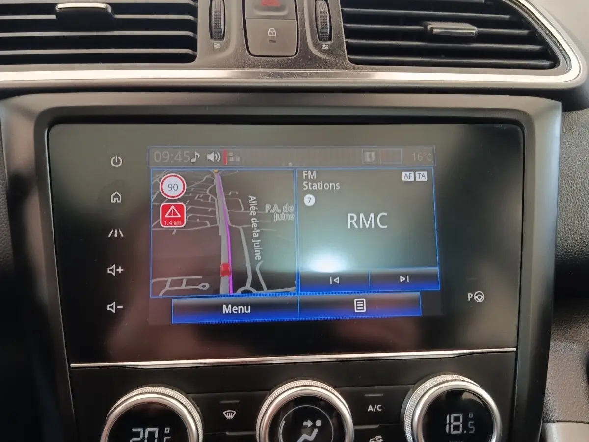 Écran tactile central du tableau de bord du Renault Kadjar blanc 2020 affichant navigation et radio RMC.