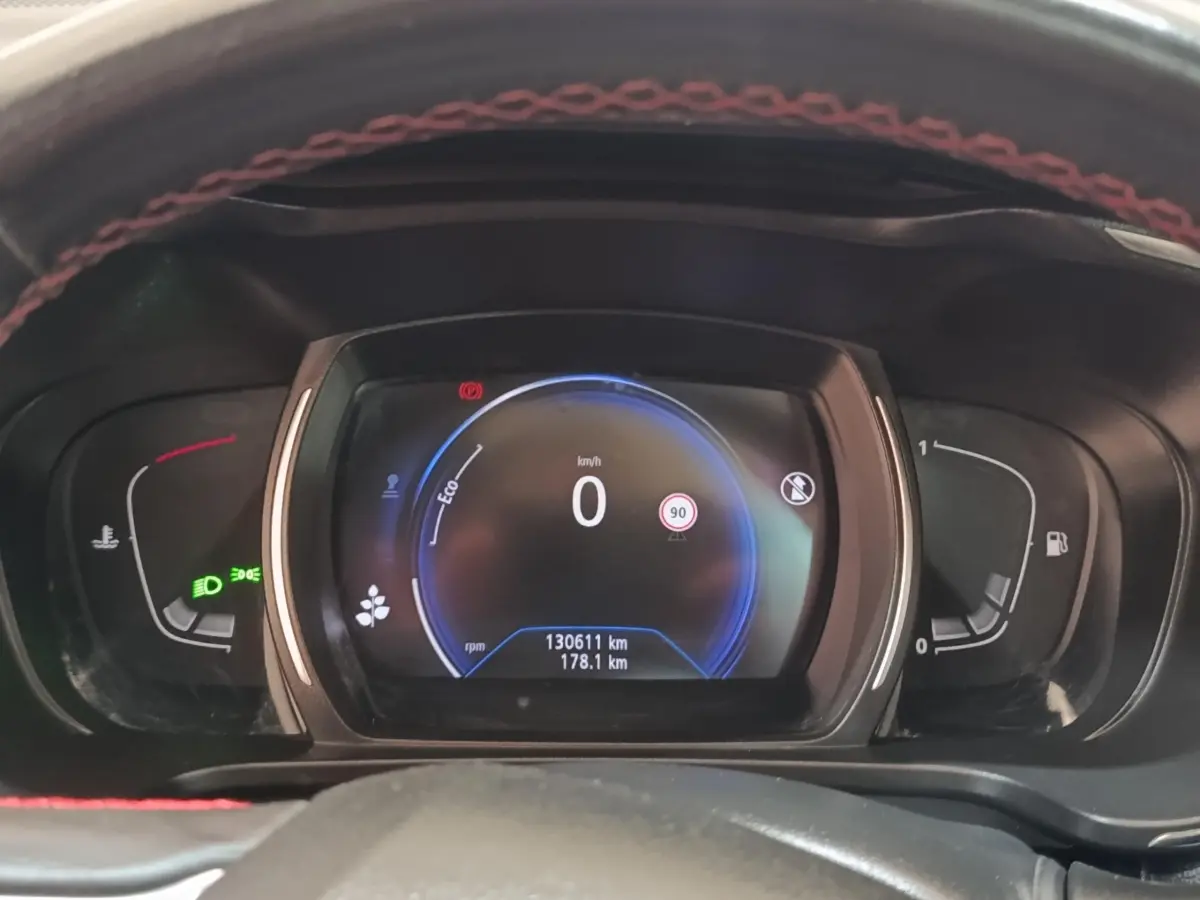 Vue rapprochée du tableau de bord numérique du Renault Kadjar blanc, affichant la vitesse à 0 km/h et divers indicateurs.