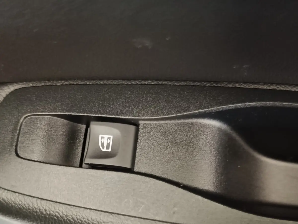 Gros plan sur bouton de commande de lève-vitre noir dans l’habitacle du Renault Kadjar blanc, version Black Edition.
