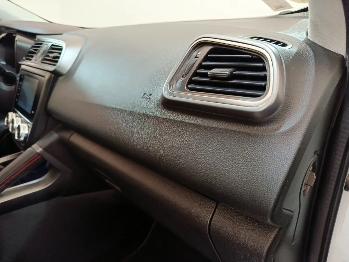 Vue intérieure côté passager du tableau de bord noir du Renault Kadjar 2020 avec sortie d'air et détails texturés.