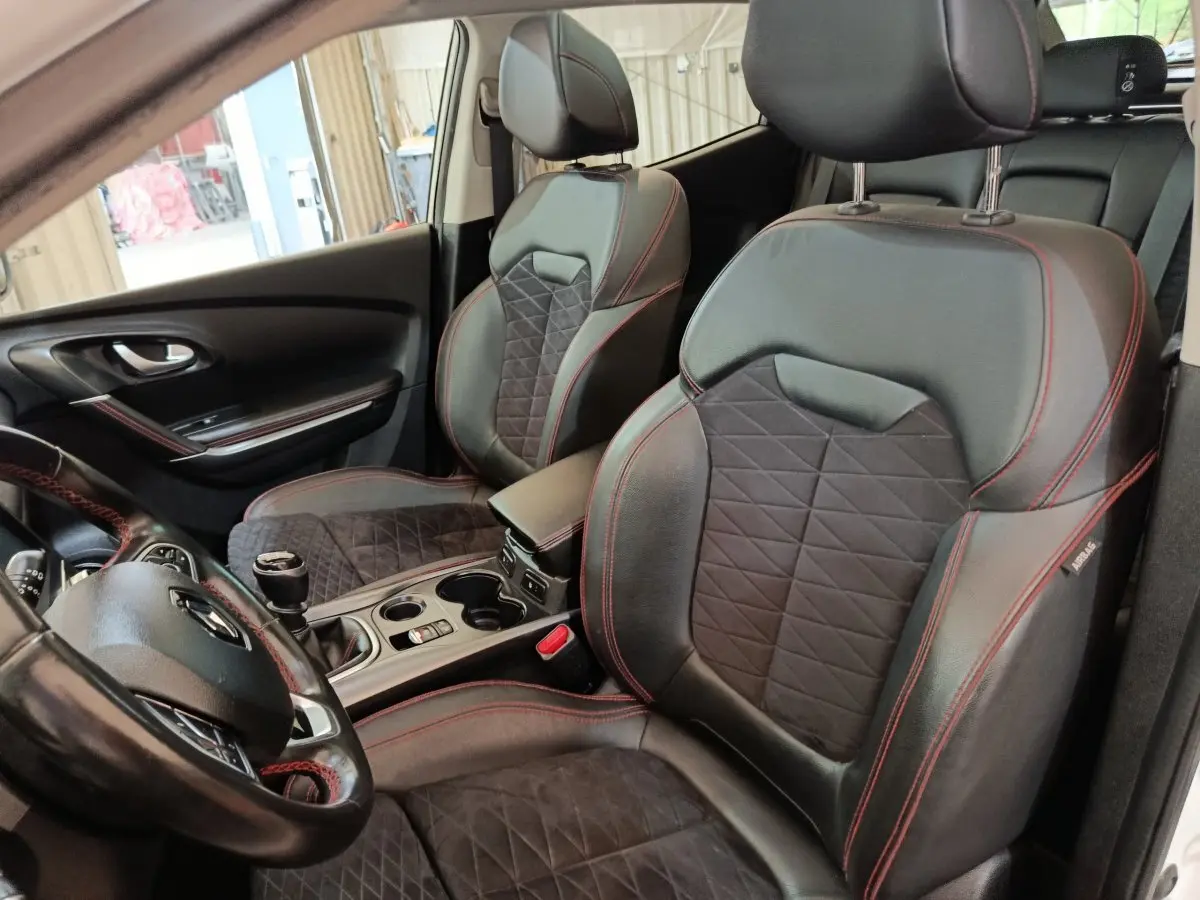Vue intérieure côté conducteur du Renault Kadjar Black Edition 2020, sièges cuir noir avec surpiqûres rouges et volant cuir.