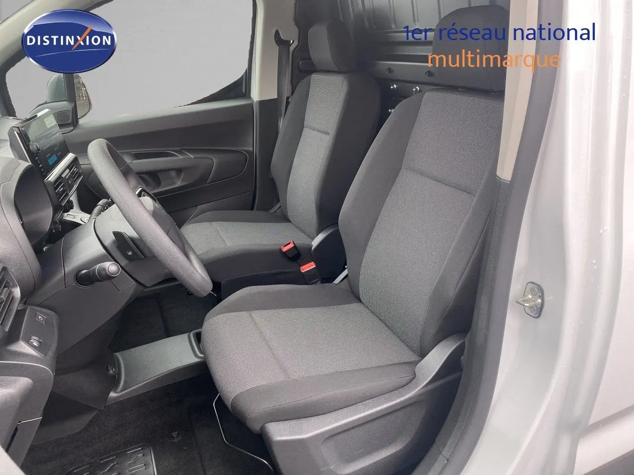Vue intérieure côté conducteur du Citroën Berlingo Fourgon blanc 2025, sièges gris et volant multifonction visible.