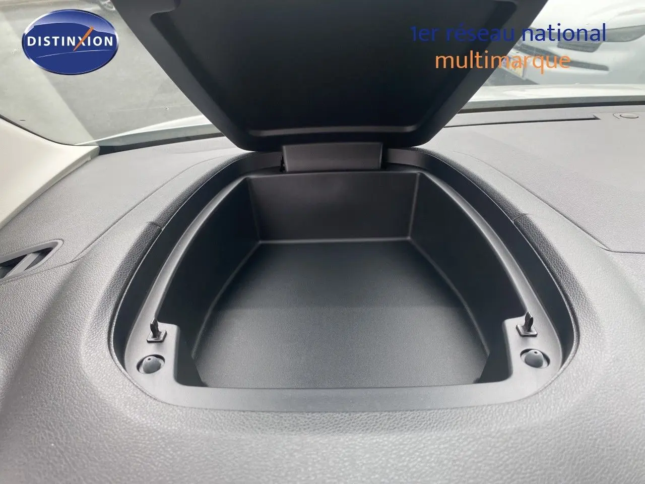 Vue rapprochée du rangement ouvert sur le tableau de bord noir du Citroën Berlingo Fourgon blanc, version 2025.