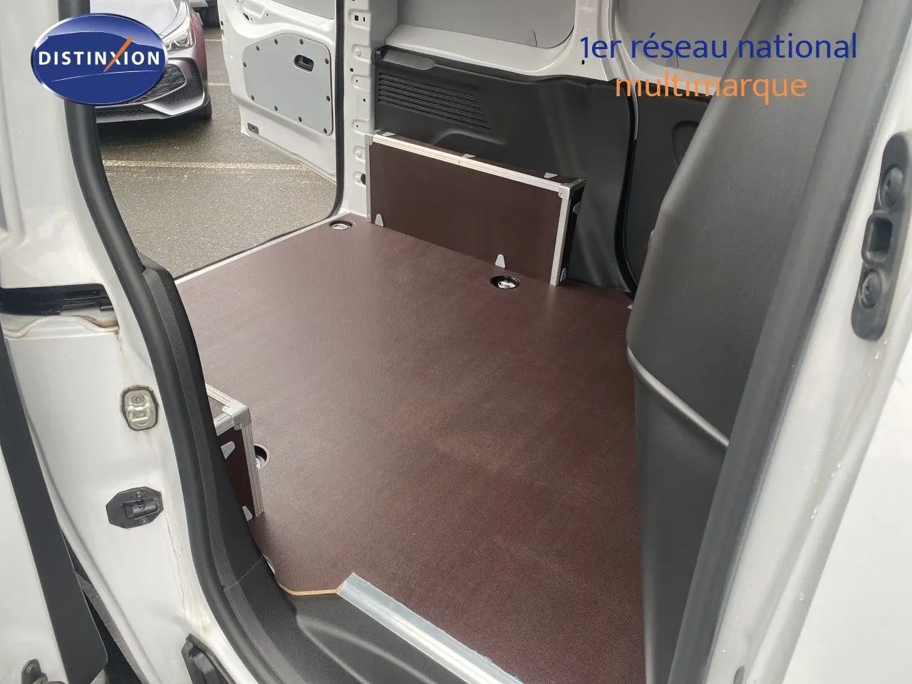 Vue intérieure de la zone de chargement du Citroën Berlingo Fourgon blanc avec porte latérale ouverte.