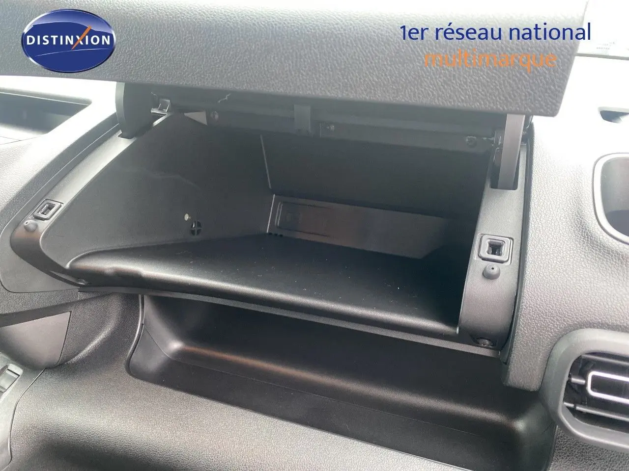Vue intérieure du coffre à gants ouvert du Citroën Berlingo Fourgon blanc, montrant la console côté passager.