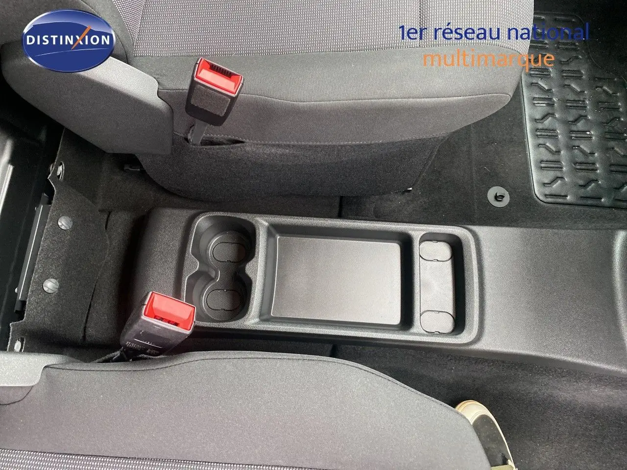 Vue plongeante sur la console centrale noire entre les sièges avant gris du Citroën Berlingo Fourgon 2025.