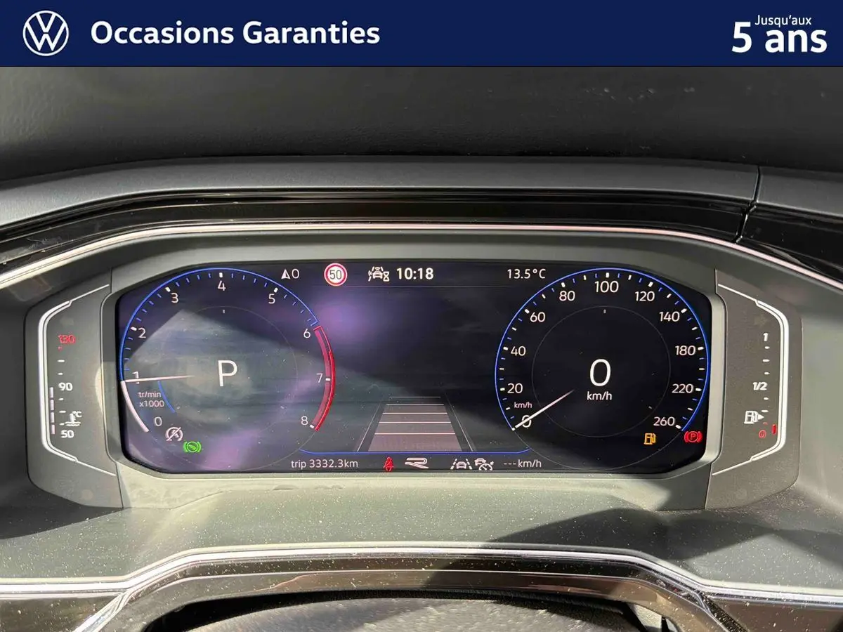 Tableau de bord digital du Volkswagen Taigo gris, affichage vitesse et compte-tours en vue frontale rapprochée.