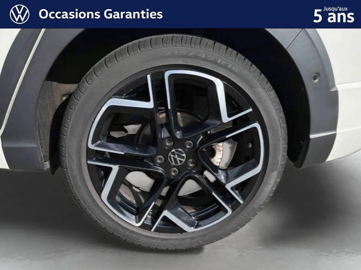 Gros plan sur la jante alliage noir et argent 18 pouces du Volkswagen Taigo gris, avec pneu 215/45 R18 visible côté arrière.
