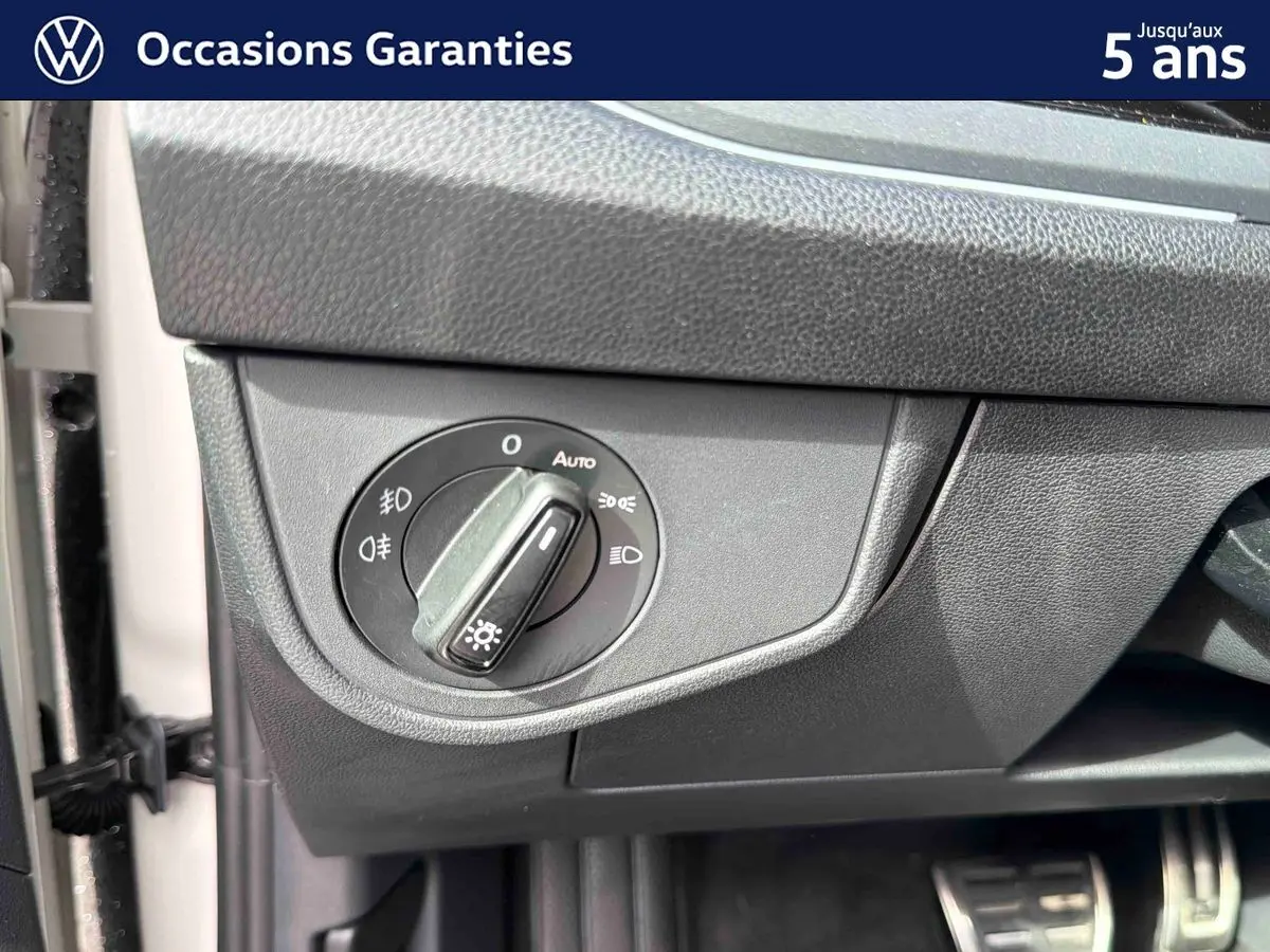 Gros plan sur le bouton de commande des phares à gauche du tableau de bord du Volkswagen Taigo gris.