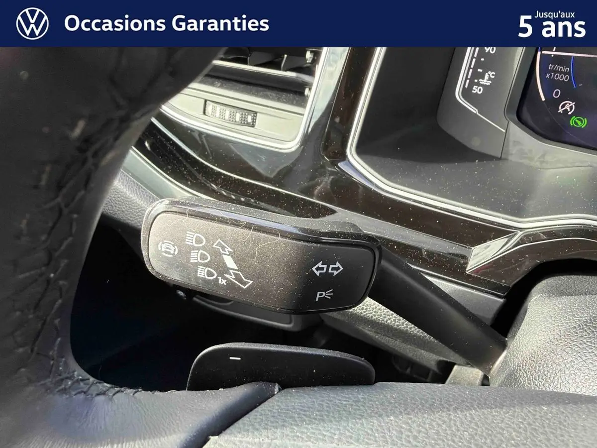 Gros plan sur la manette de clignotants noire et le tableau de bord digital du Volkswagen Taigo 2025.