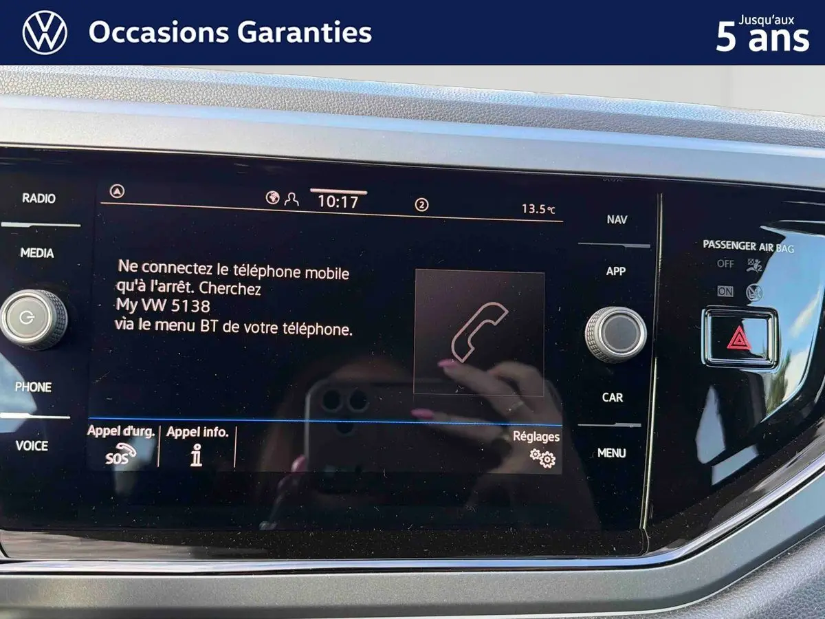 Écran tactile central du Volkswagen Taigo gris, affichant les options de connexion Bluetooth et commandes autour.