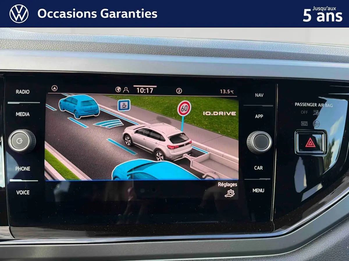 Écran tactile du tableau de bord montrant l'assistance au stationnement avec représentation virtuelle du Volkswagen Taigo gris.