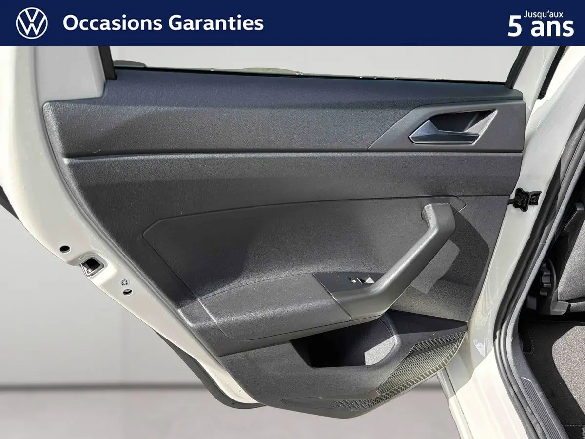 Vue rapprochée de la porte arrière gauche grise du Volkswagen Taigo 2025 avec intérieur noir et poignée intégrée.