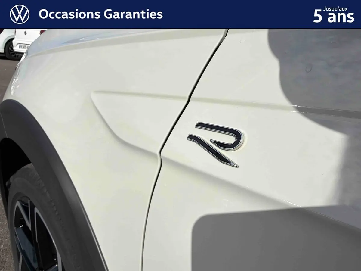 Détail de l'aile avant droite grise du Volkswagen Taigo avec logo R visible sur la carrosserie.
