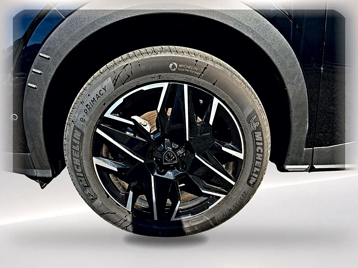 Gros plan sur la roue avant droite noire avec jante alu noire et argentée du Peugeot 5008 Hybrid 145 GT e-dcs6 noir.