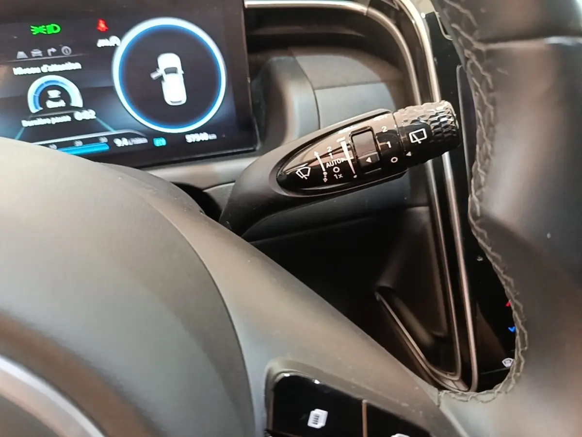 Gros plan sur la commande d’essuie-glace à droite du volant dans l’habitacle du Hyundai Tucson bleu 2021.