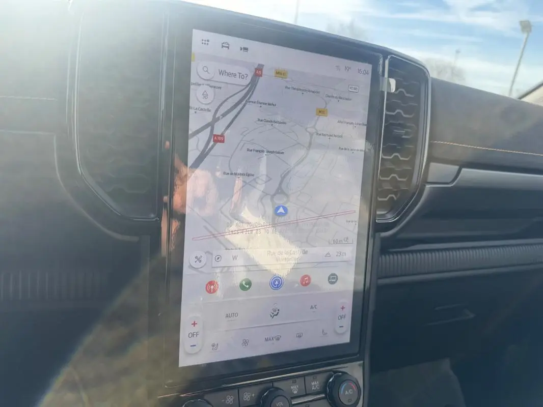 Vue intérieure centrée sur l'écran tactile vertical du Ford Ranger gris 2025, avec tableau de bord et aérateurs visibles.
