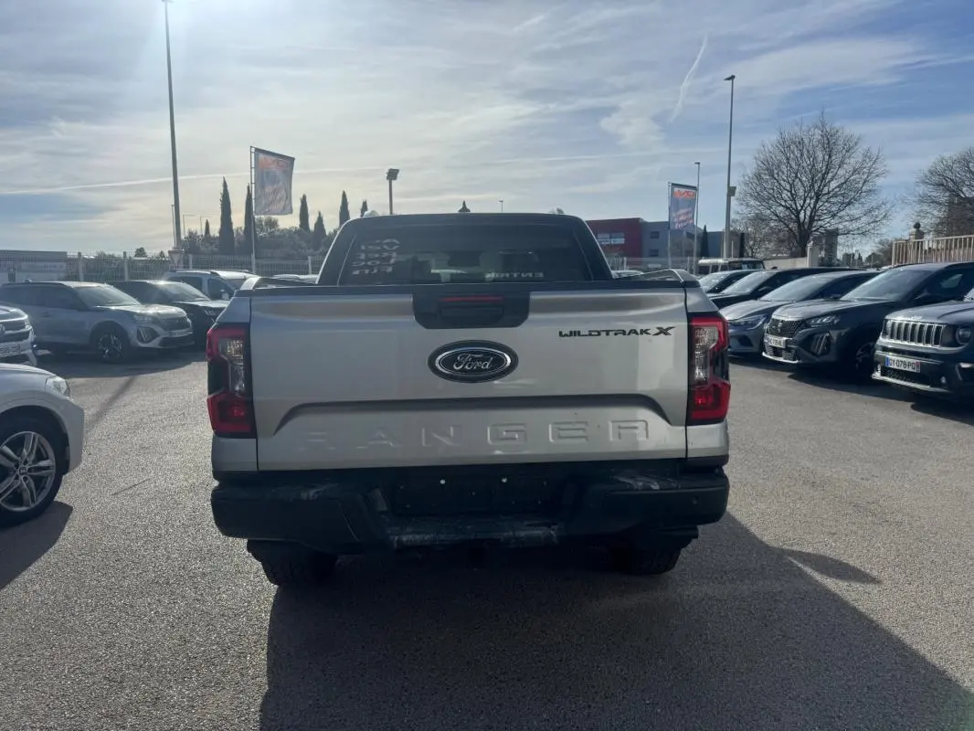 Vue arrière d'un Ford Ranger gris Wildtrak X avec hayon marqué Ranger et feux arrière rouges visibles.
