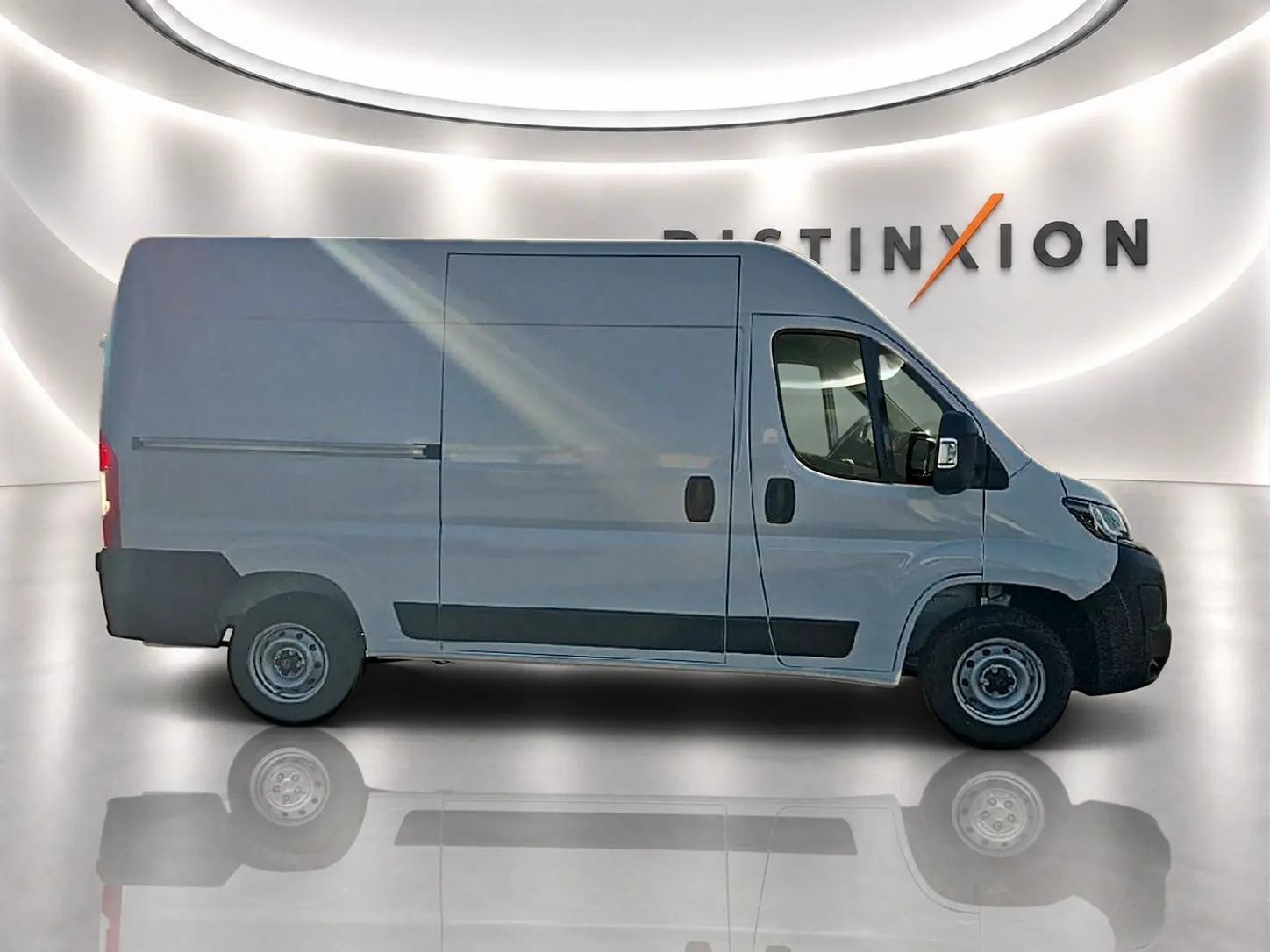 Vue de profil côté gauche du Peugeot Boxer Fourgon blanc L2H2 dans un showroom lumineux avec porte latérale coulissante visible.