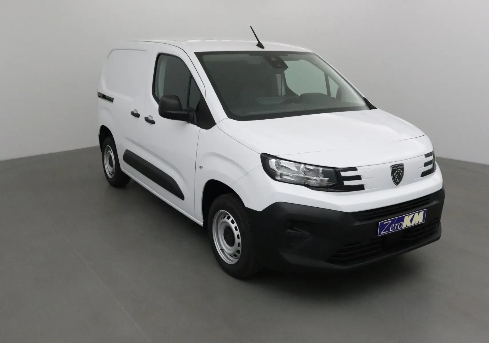 Peugeot Partner blanc en 3/4 avant droit, fourgon utilitaire avec pare-chocs noirs et jantes acier simples.