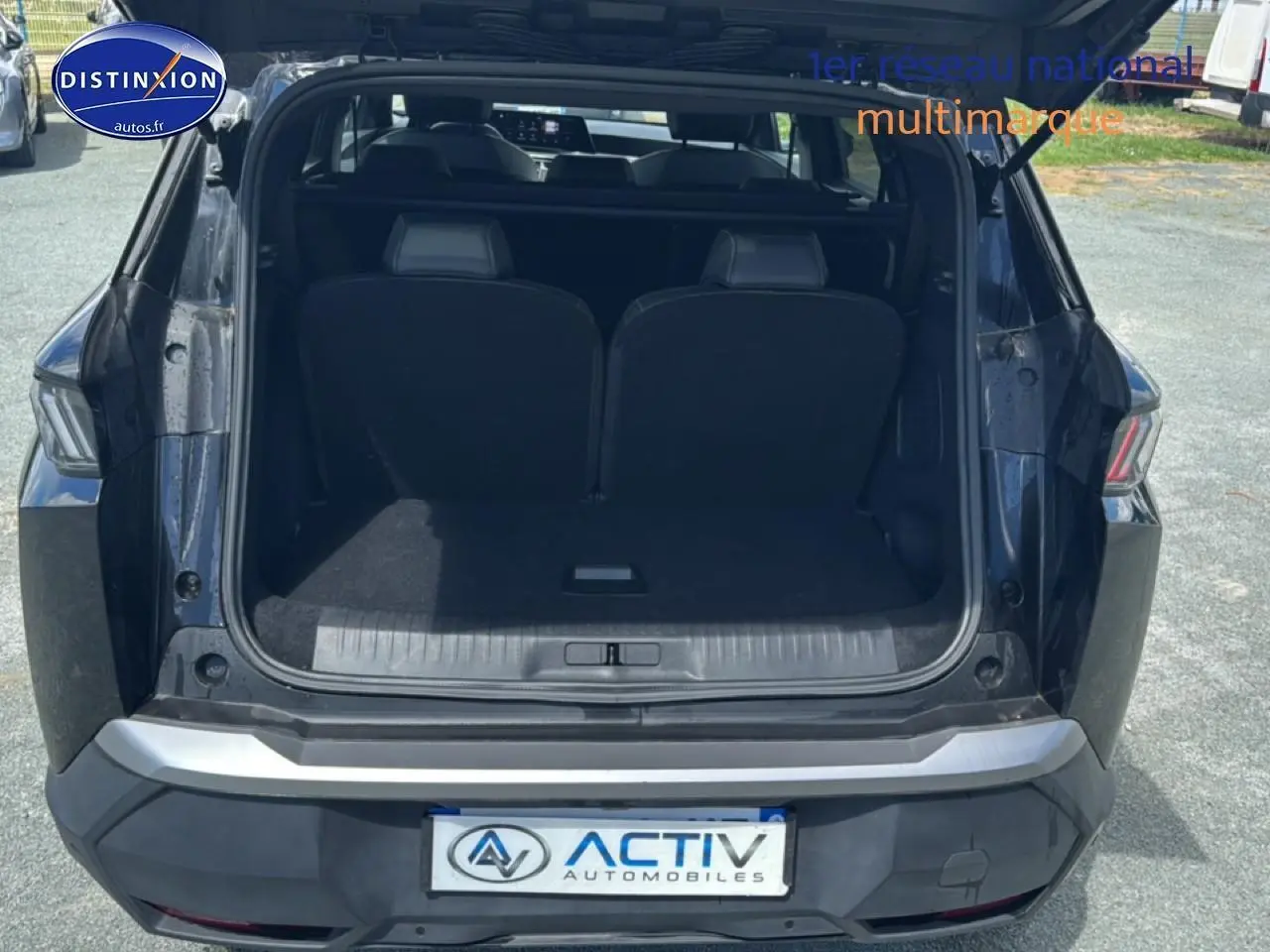 Peugeot 5008 Hybrid 145 allure noir vu de l'arrière avec coffre ouvert et sièges rang 3 visibles.
