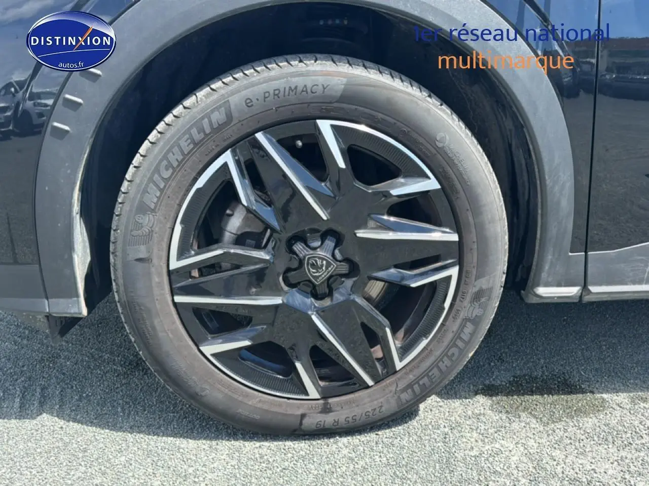 Gros plan sur la roue avant gauche noire avec jante alu au design moderne du Peugeot 5008 Hybrid 145 allure e-dcs6.