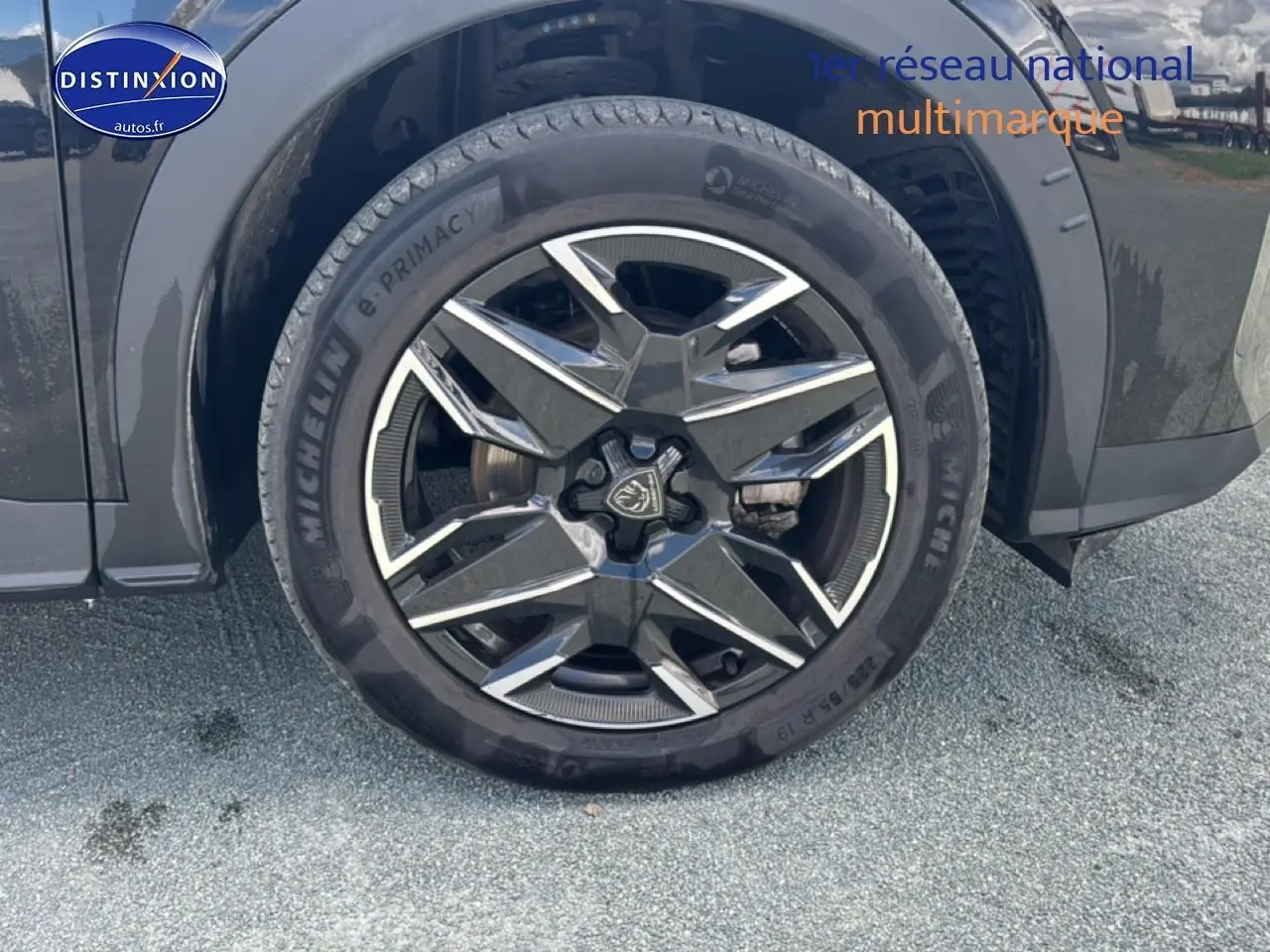 Gros plan sur la roue avant droite noire du Peugeot 5008 Hybrid 145 allure e-dcs6 avec jante alu distinctive.