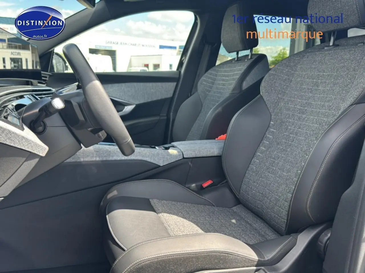 Vue intérieure côté conducteur du Peugeot 5008 Hybrid 145 allure e-dcs6 2025 avec sièges tissu gris et cuir noir.