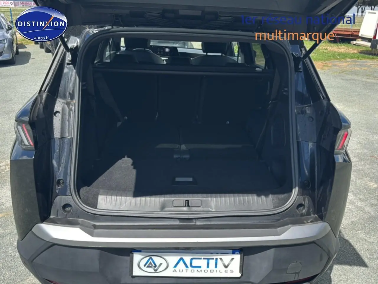 Vue arrière du coffre ouvert du Peugeot 5008 Hybrid 145 allure e-dcs6 noir, montrant l’espace de chargement avec banquette rabattue.