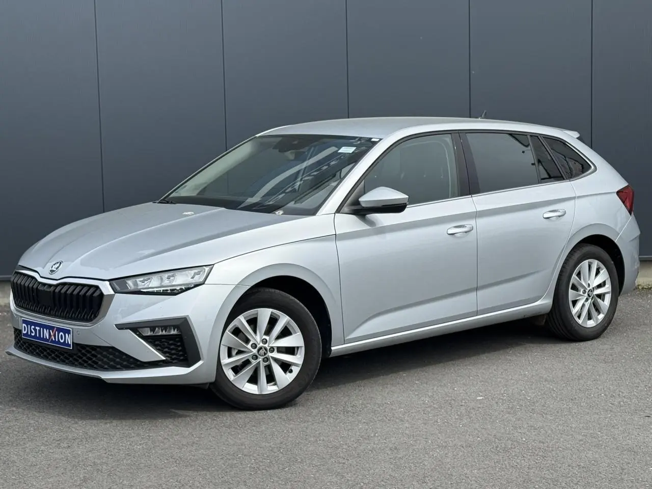 Vue 3/4 avant droite d'une Skoda Scala gris reflex avec jantes alliage 16 pouces et vitres surteintées.