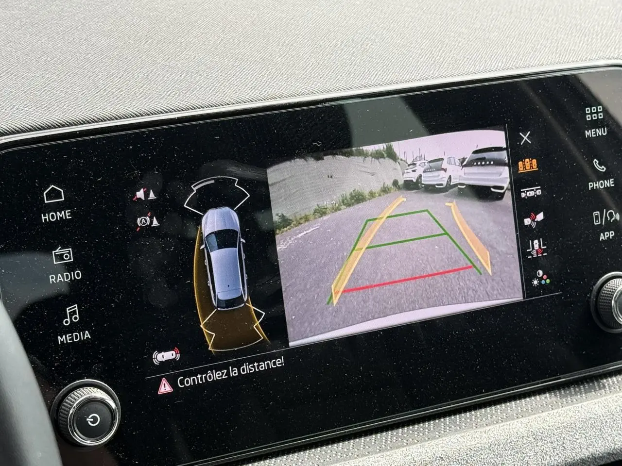 Écran intérieur affichant la caméra de recul et les capteurs de distance du Skoda Scala gris Reflex.