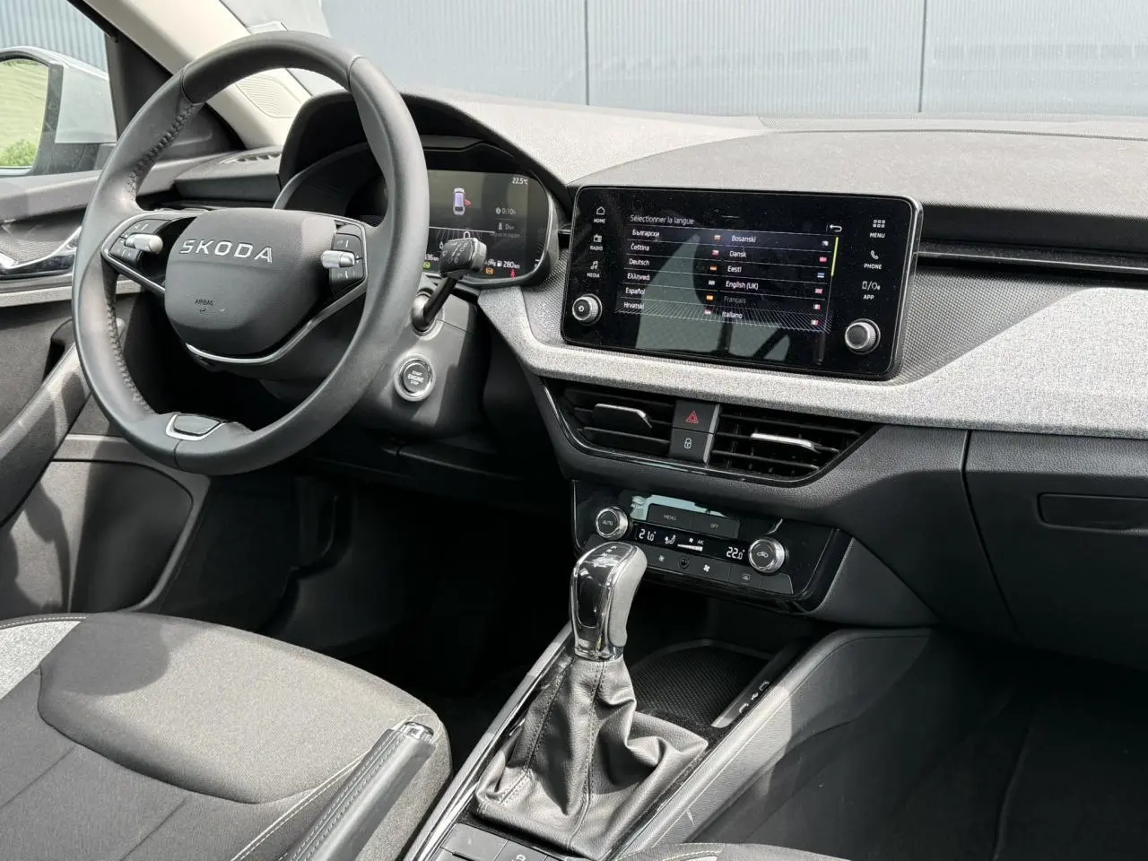 Intérieur de la Skoda Scala TSI 116 DSG7, vue côté conducteur, tableau de bord gris clair avec écran tactile 8,25 pouces.