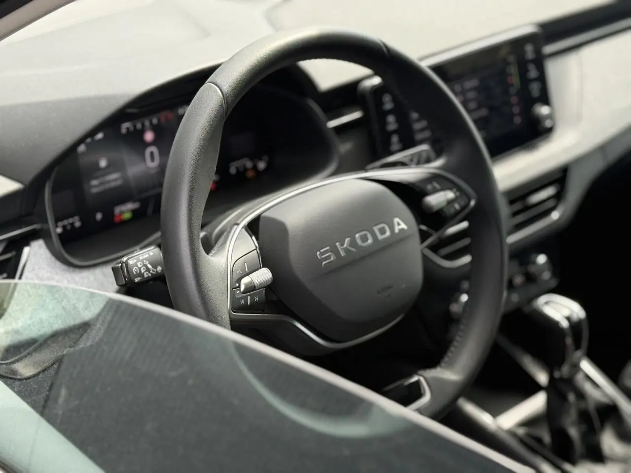 Vue rapprochée du volant en cuir multifonctions de la Skoda Scala 2025, avec tableau de bord numérique en arrière-plan.