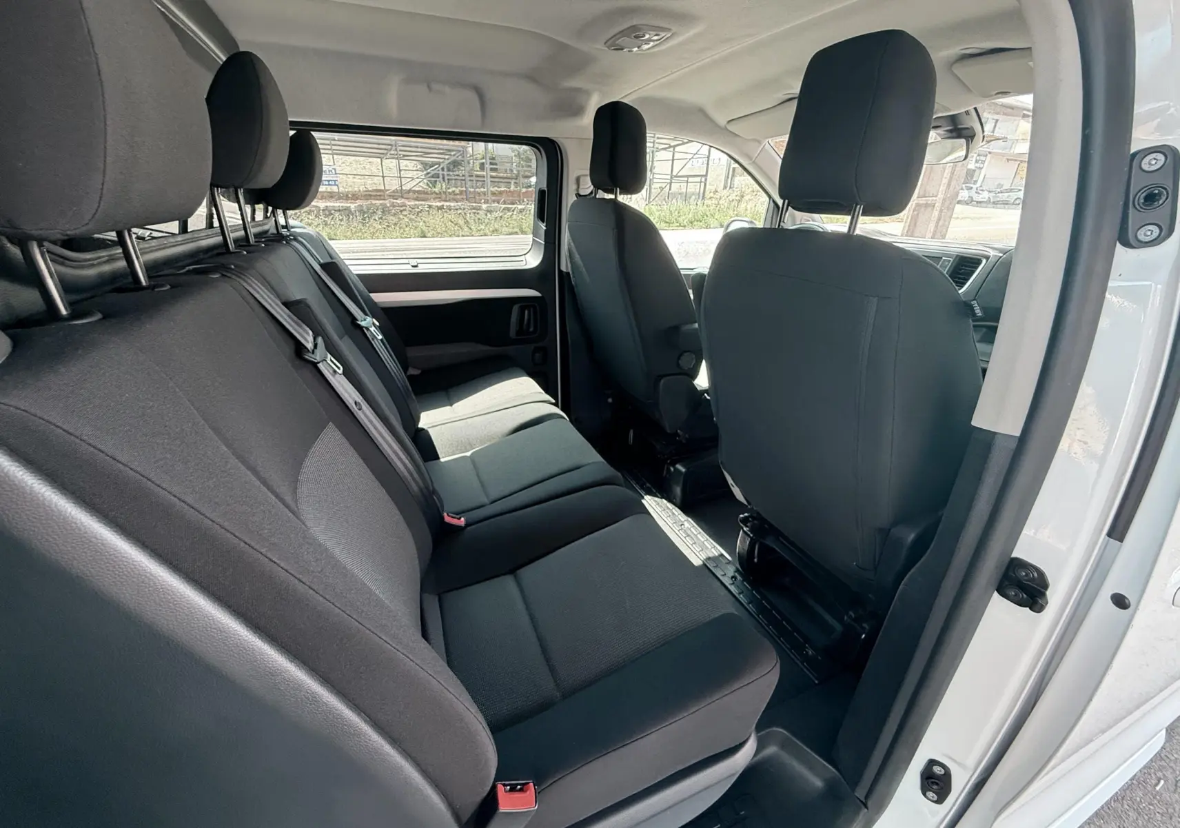 Vue intérieure côté droit du Peugeot Expert cabine approfondie blanc, montrant les sièges arrière en tissu gris noir.