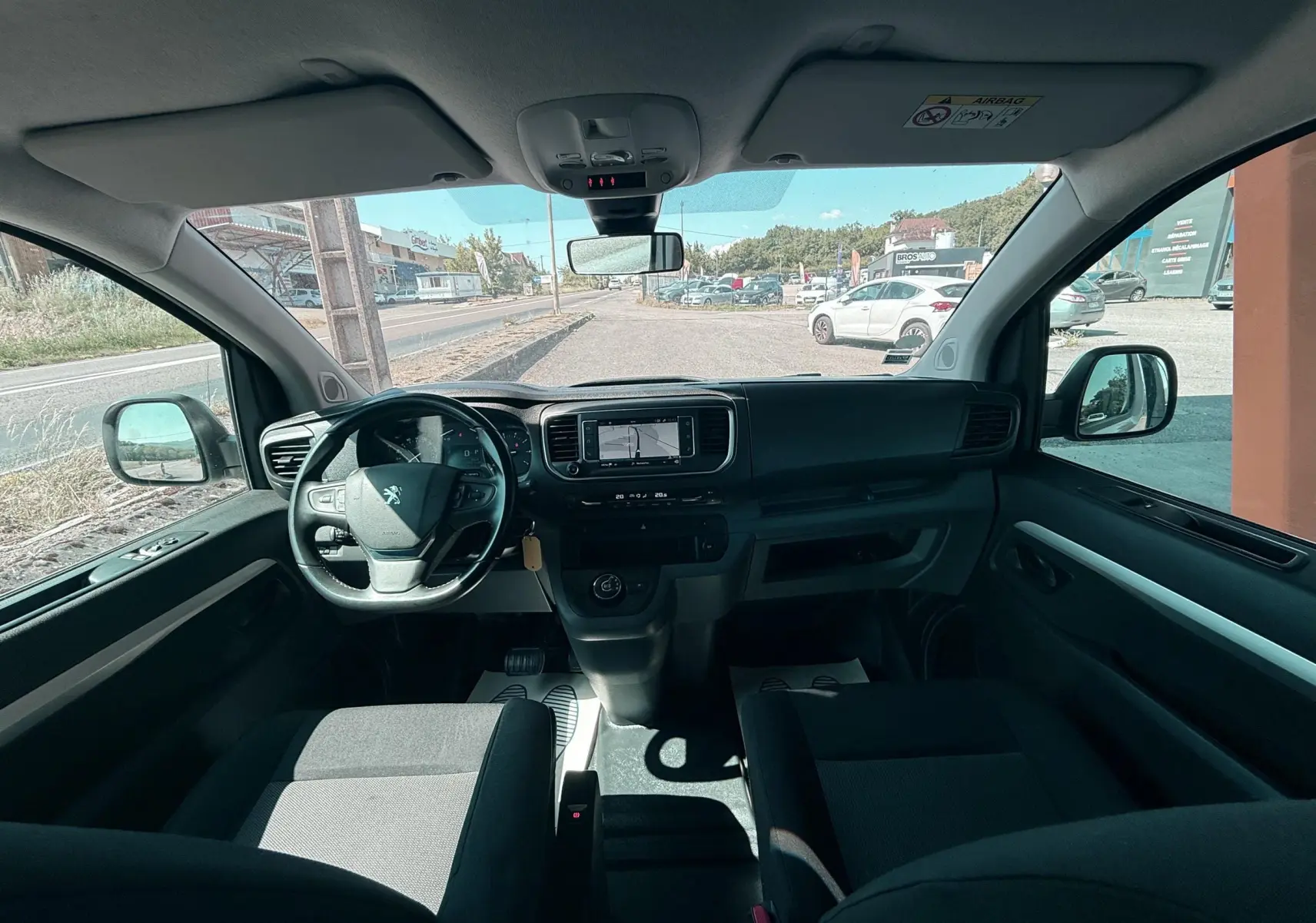 Vue intérieure avant du Peugeot Expert cabine approfondie 2022, tableau de bord noir avec écran central et volant multifonction.